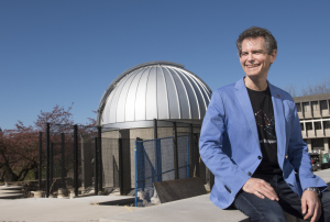 SFU Physics professor Howard Trottier, brother of Lorne Trottier,  and the Trottier Observatory in the background (Photo Credit: Simon Fraser University)